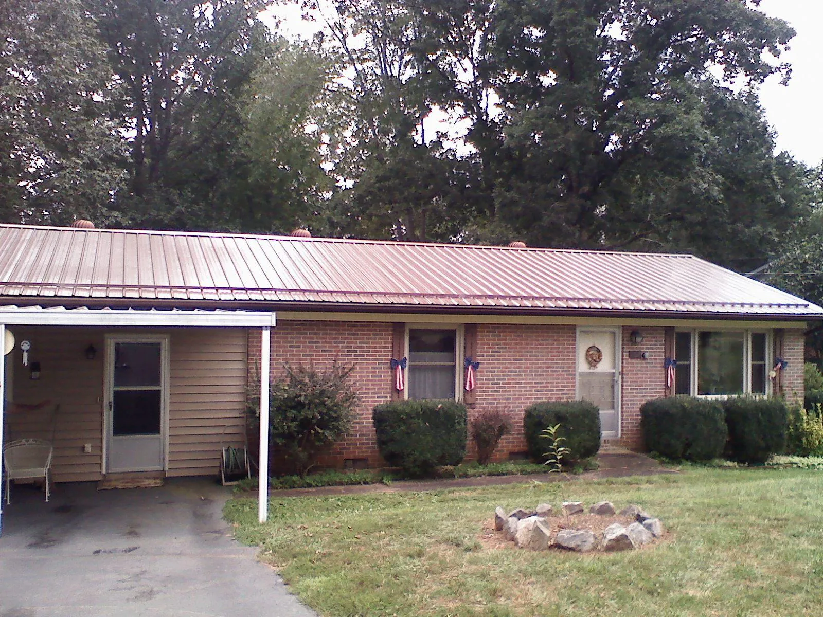 Bronze metal roof and carport on a brick ranch home — Roof Repair work by our crew in Mcintosh