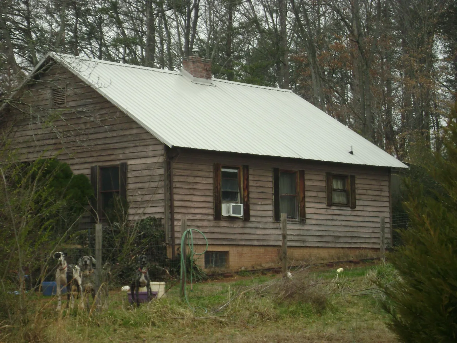 White metal roof on an old wood sided farmhouse, from a Metal Roof Installation job in Mcintosh